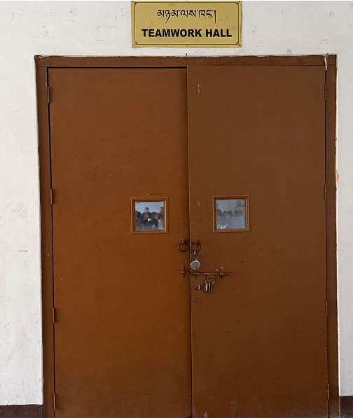 The current plain wooden door of the hall